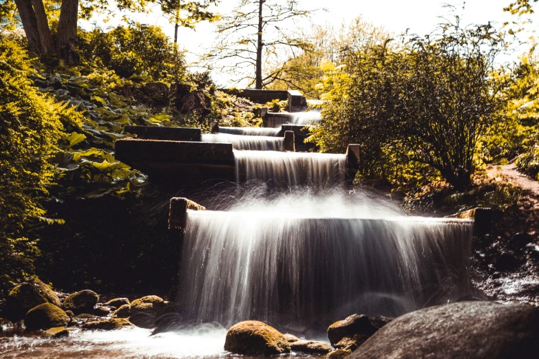 a waterfall filled with lots of water surrounded by trees