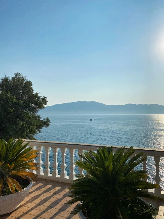 a balcony overlooking a calm sea and trees