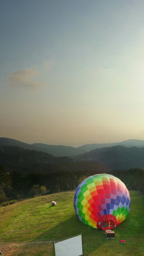 a multicolored balloon sits on a grassy field