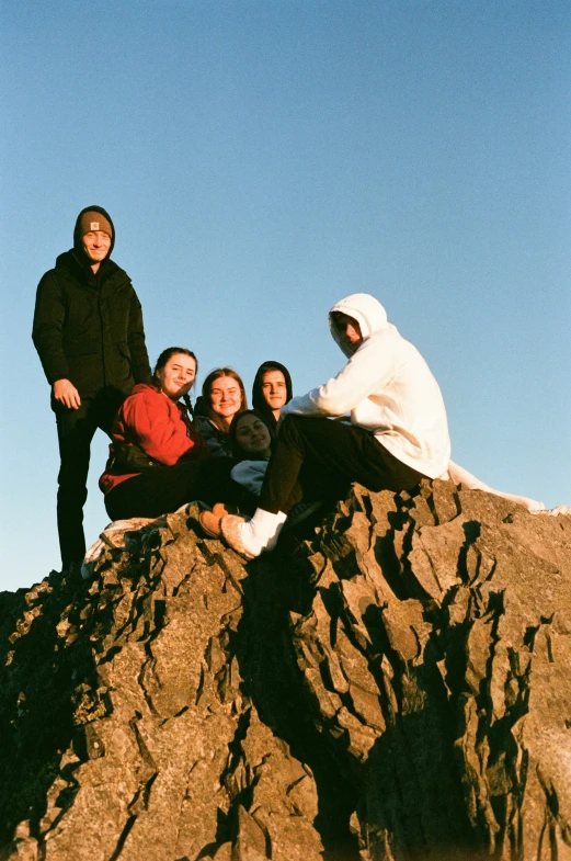 four young people posing on top of a mountain