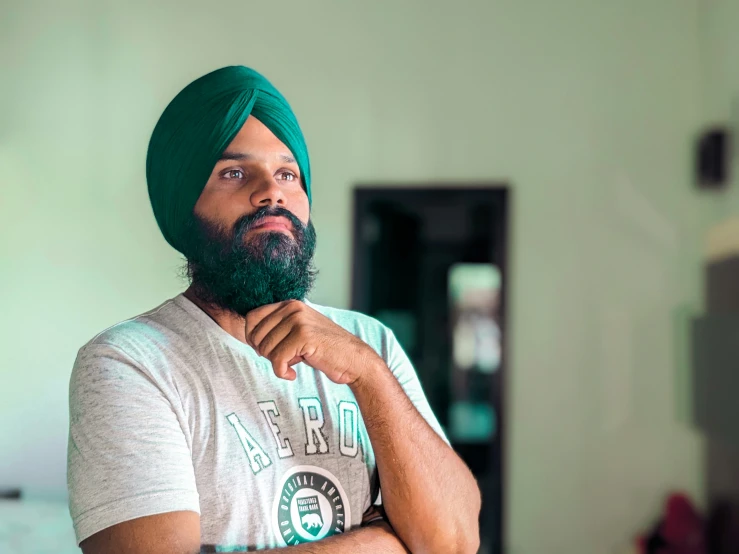 a man wearing a green turban while standing in a room