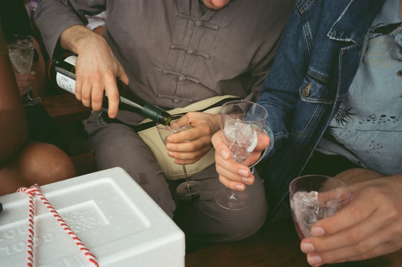 a group of people are sitting down drinking wine