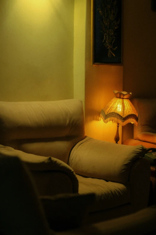 a couch sitting next to a lamp on a night stand