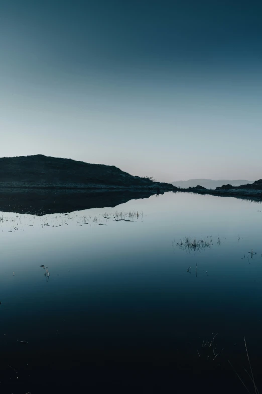 a body of water with a lone cloud in the sky