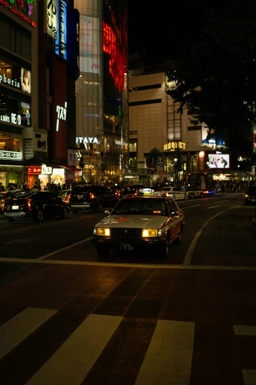 cars traveling through a crosswalk at night time