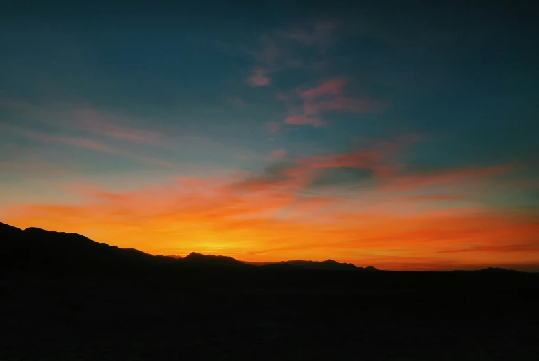 a mountain at sunrise with the sun about to rise