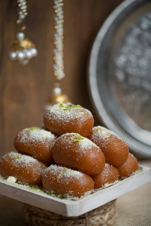 a close up of a tray of powdered sugar donuts