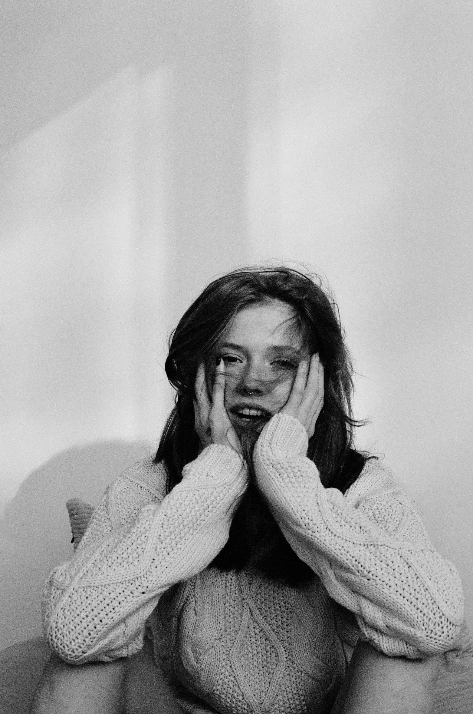 a woman is covering her eyes with her hands