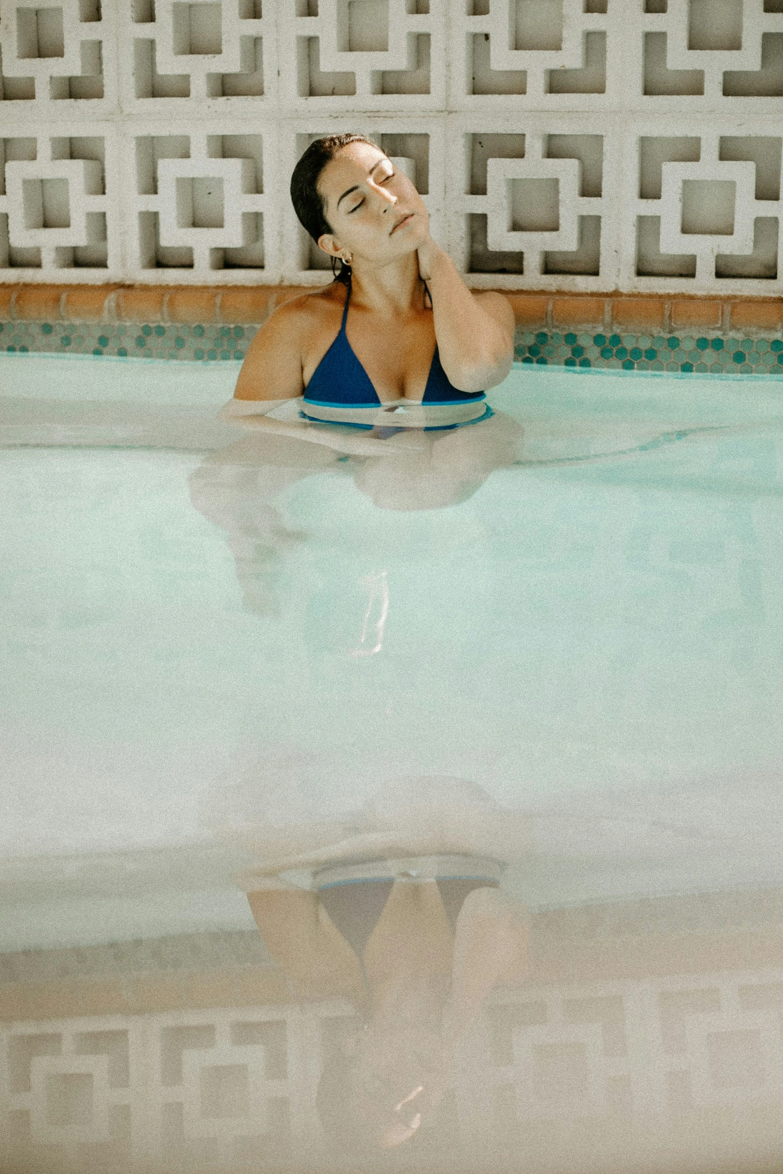a woman sitting on her stomach in a swimming pool