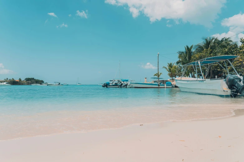 a beach with boats docked and a blue sky