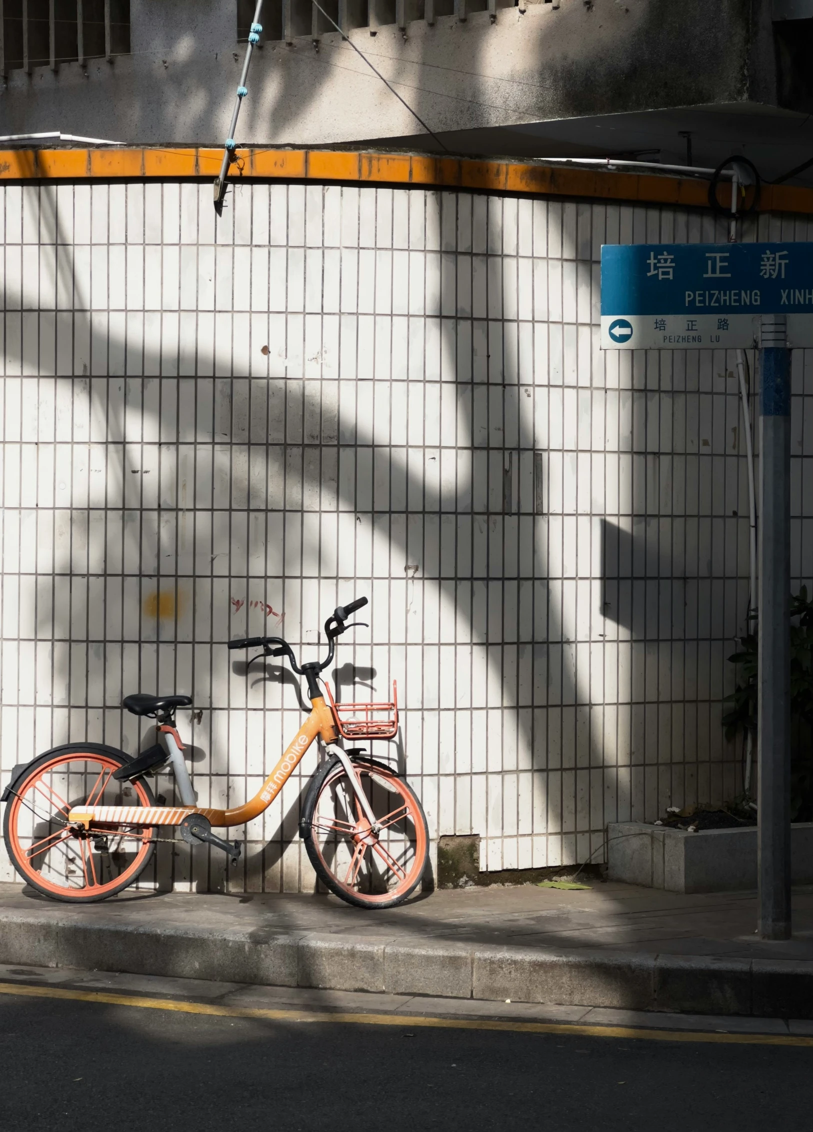 a bicycle parked on the sidewalk next to a wall