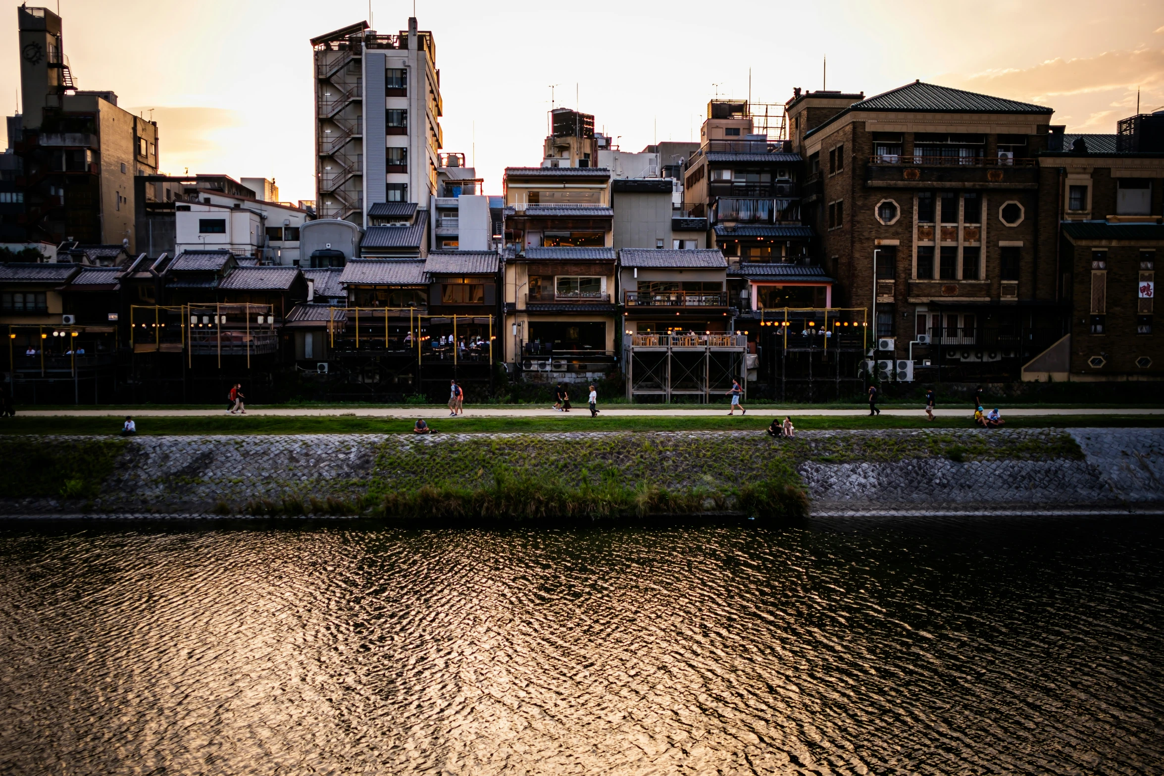 several buildings stand near the water of a river