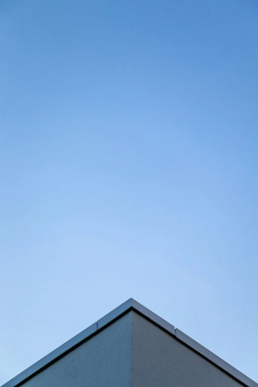 a bird is flying high in the air near a building