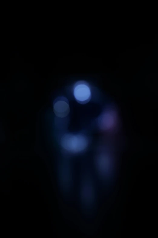 a blurred image of a dark and bright object with blurry lights