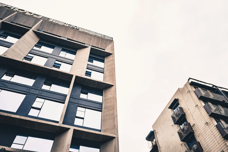 two tall buildings with large windows and balconies