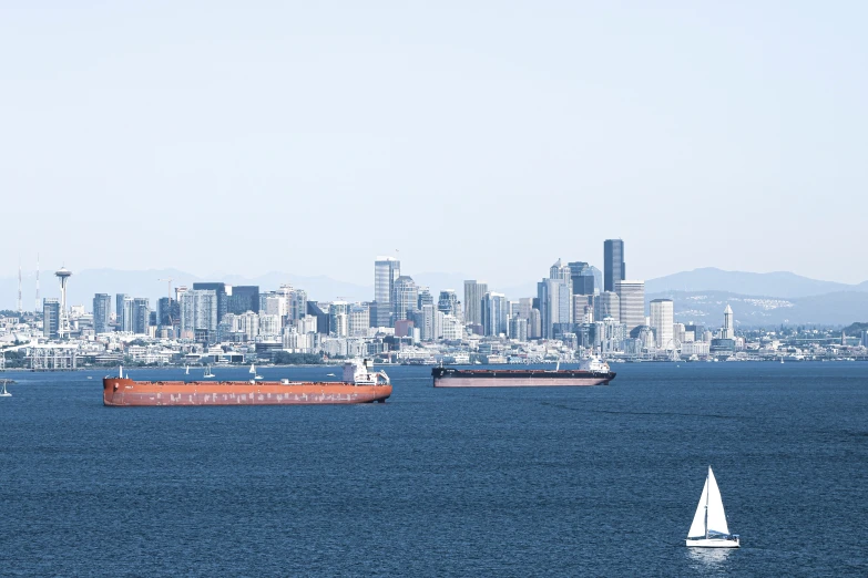 two boats with a city skyline behind them