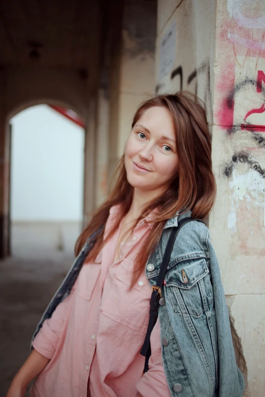 there is a pretty lady standing in front of the wall