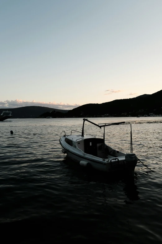 an empty boat floating in the ocean at dusk