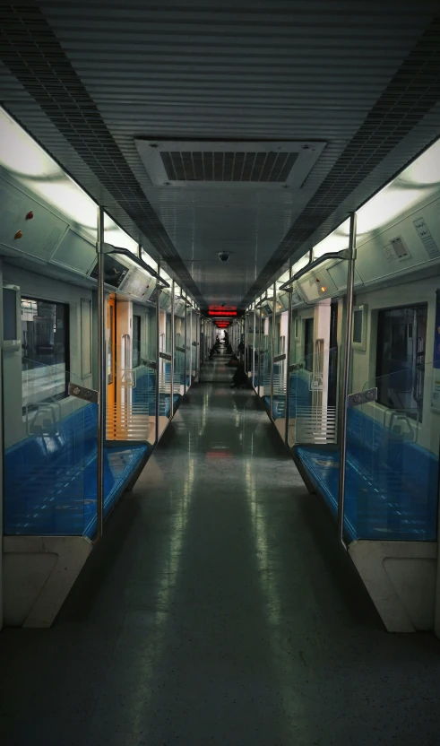 a subway station with many doors that leads into an empty hallway