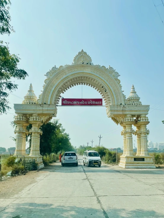 an archway in the middle of a town with parked cars