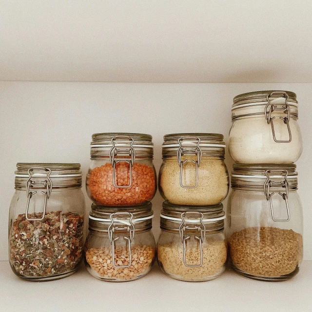 jars are lined up on a shelf filled with spices