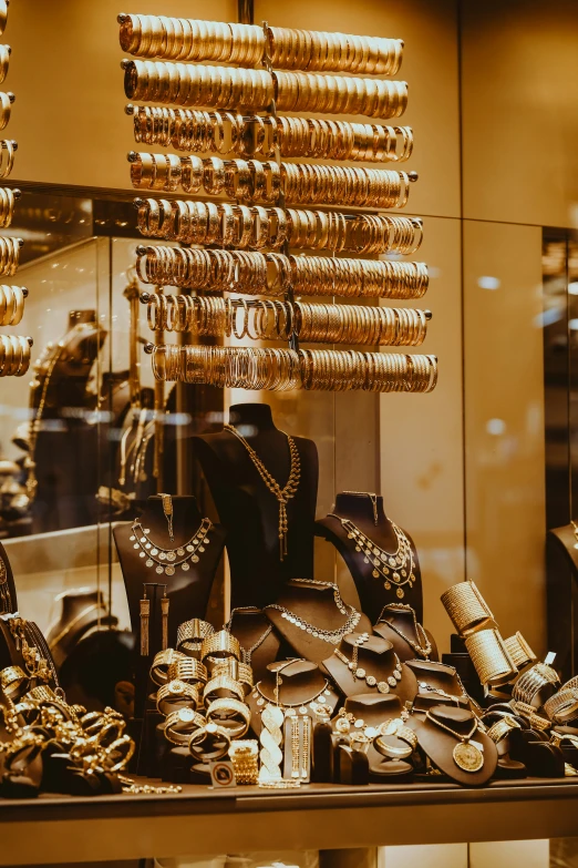 a display with gold jewelry and lots of rings