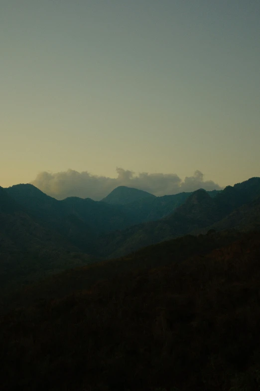 an airplane flying over mountains and a cloud