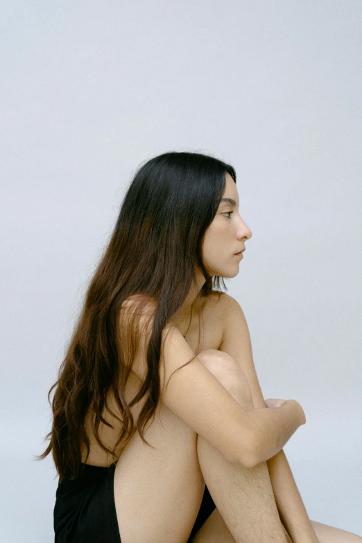 a woman sitting on the ground with long brown hair