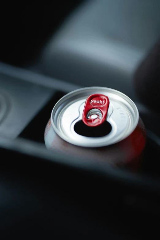 a close up view of a soda can with a red cap