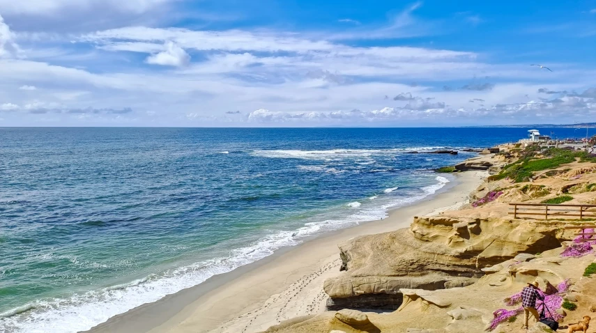 a cliff next to a beach and ocean