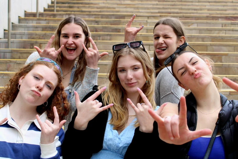 some teenage girls are standing together on a staircase