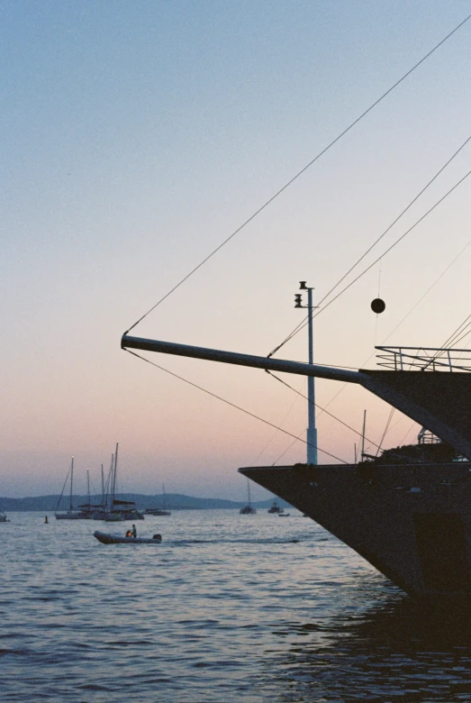 some boats are sailing in the sea near a big ship