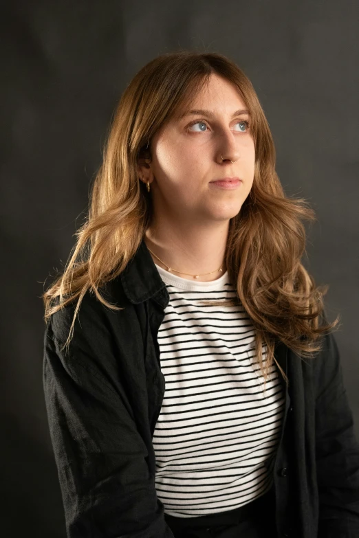 the woman with long hair wearing a striped shirt and jacket