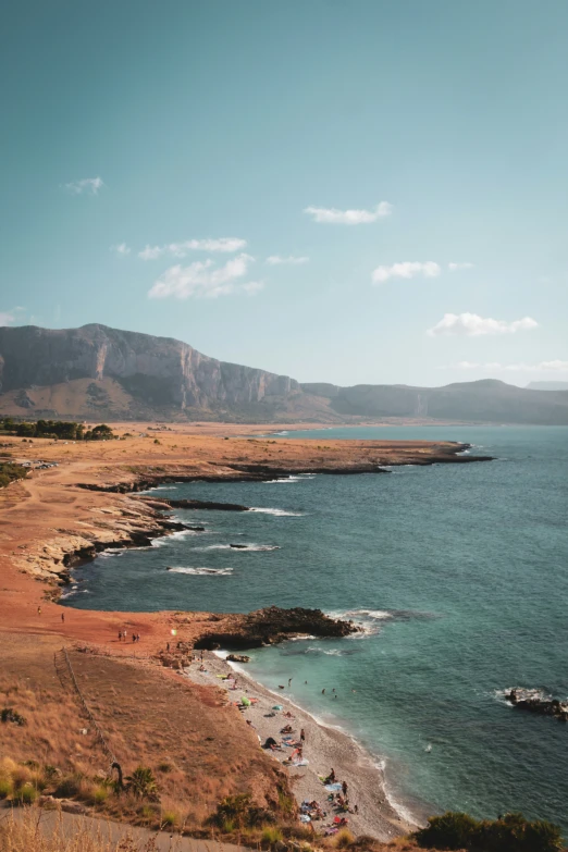 people are standing on the edge of a beach