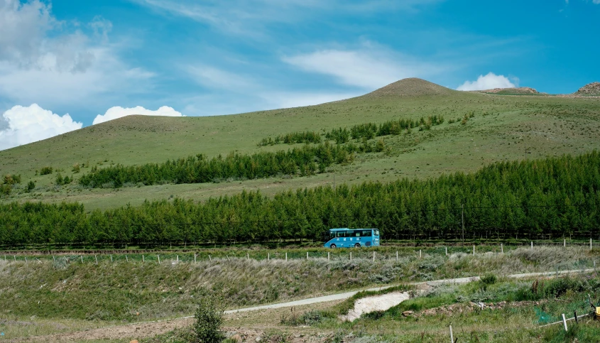 a train engine pulling many carts through the countryside