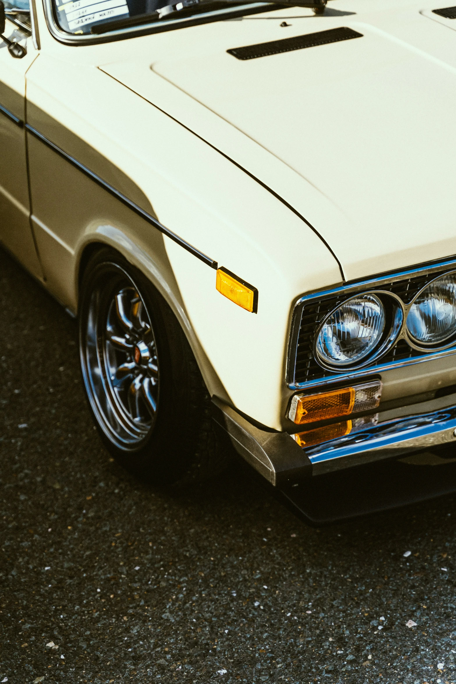 a white car with a black backlight sits in the middle of the street