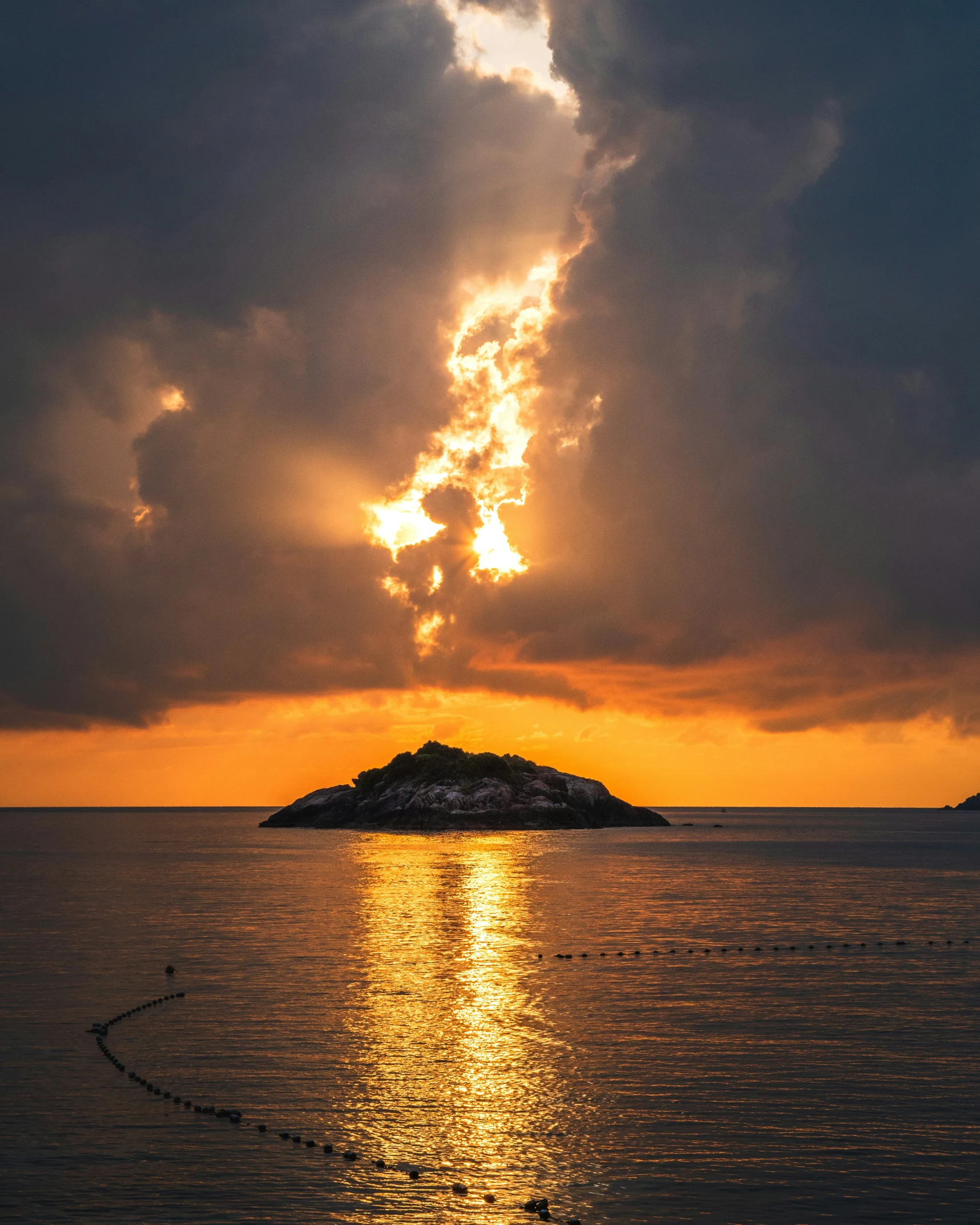 the sun reflecting off the water and a small island