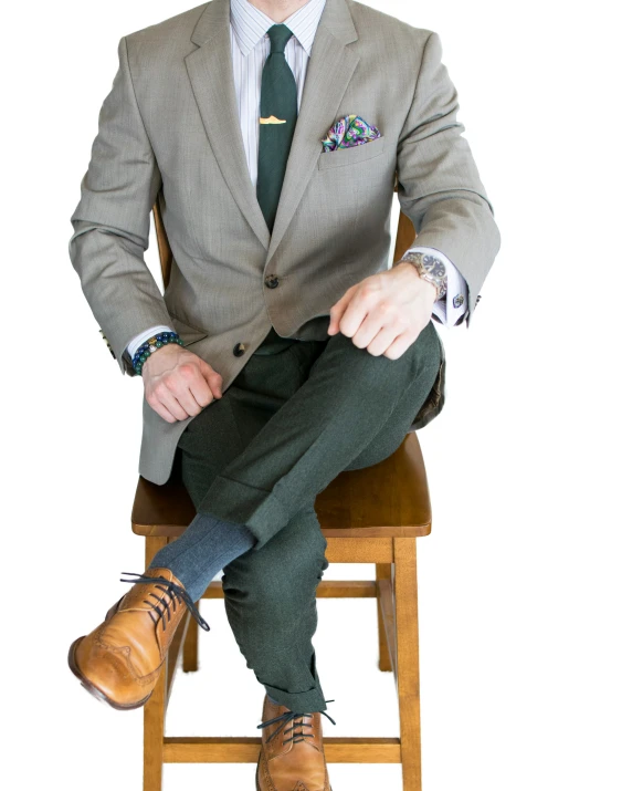 man sitting on stool with suit and tie on