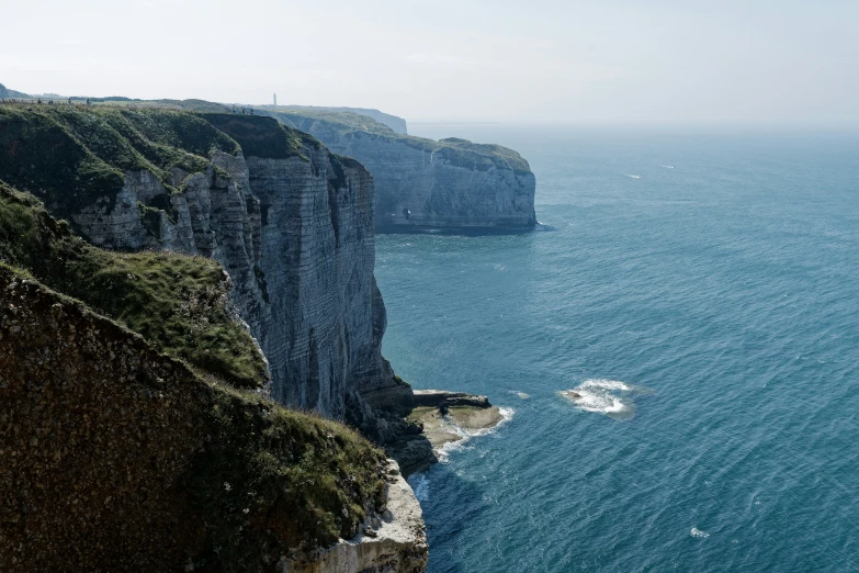 a cliff by the ocean with lots of water