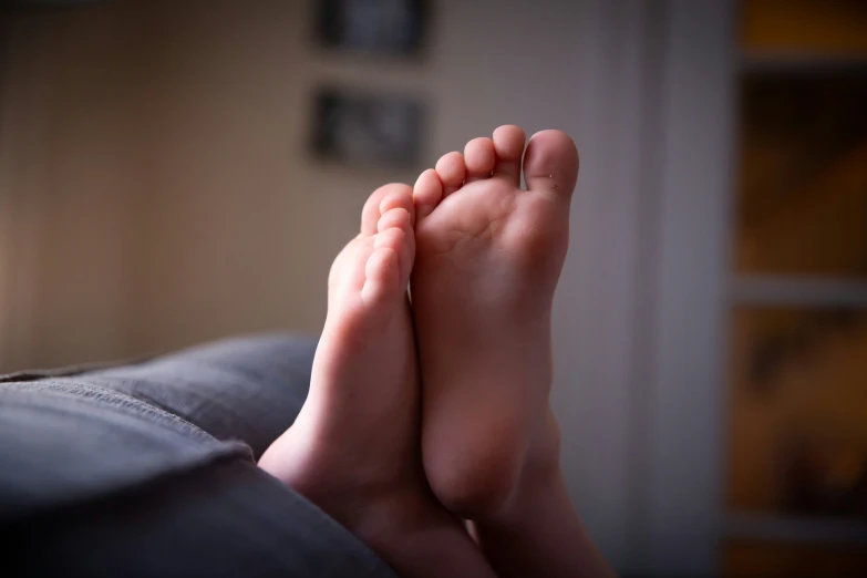 an infant has their foot on the bed