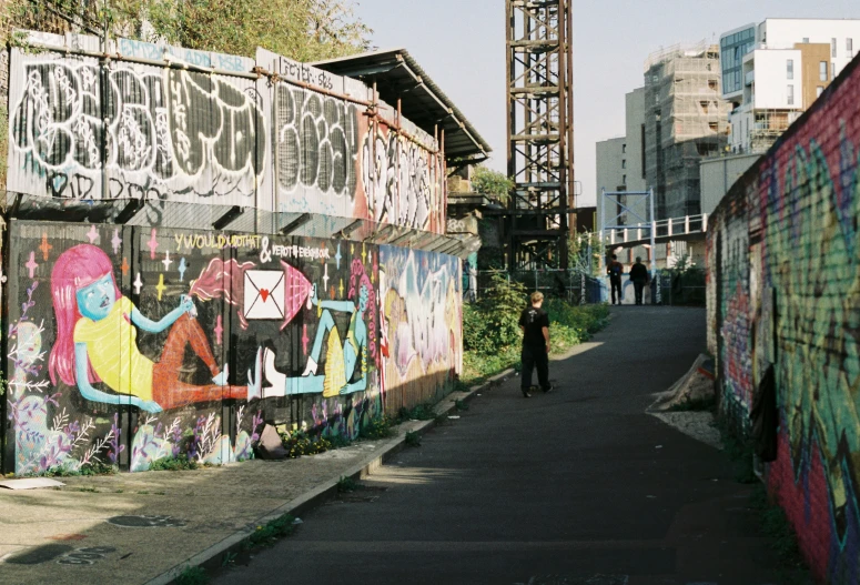 a city street filled with lots of graffiti and lots of scaffolding