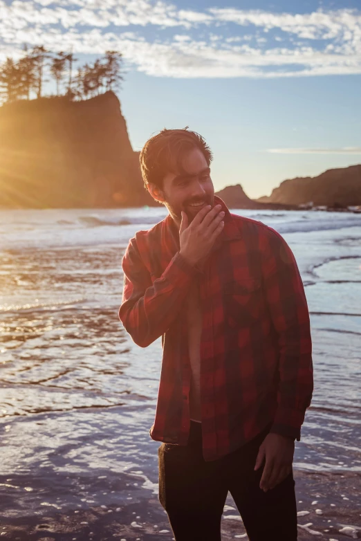 a person in the water by the shore with sun and clouds