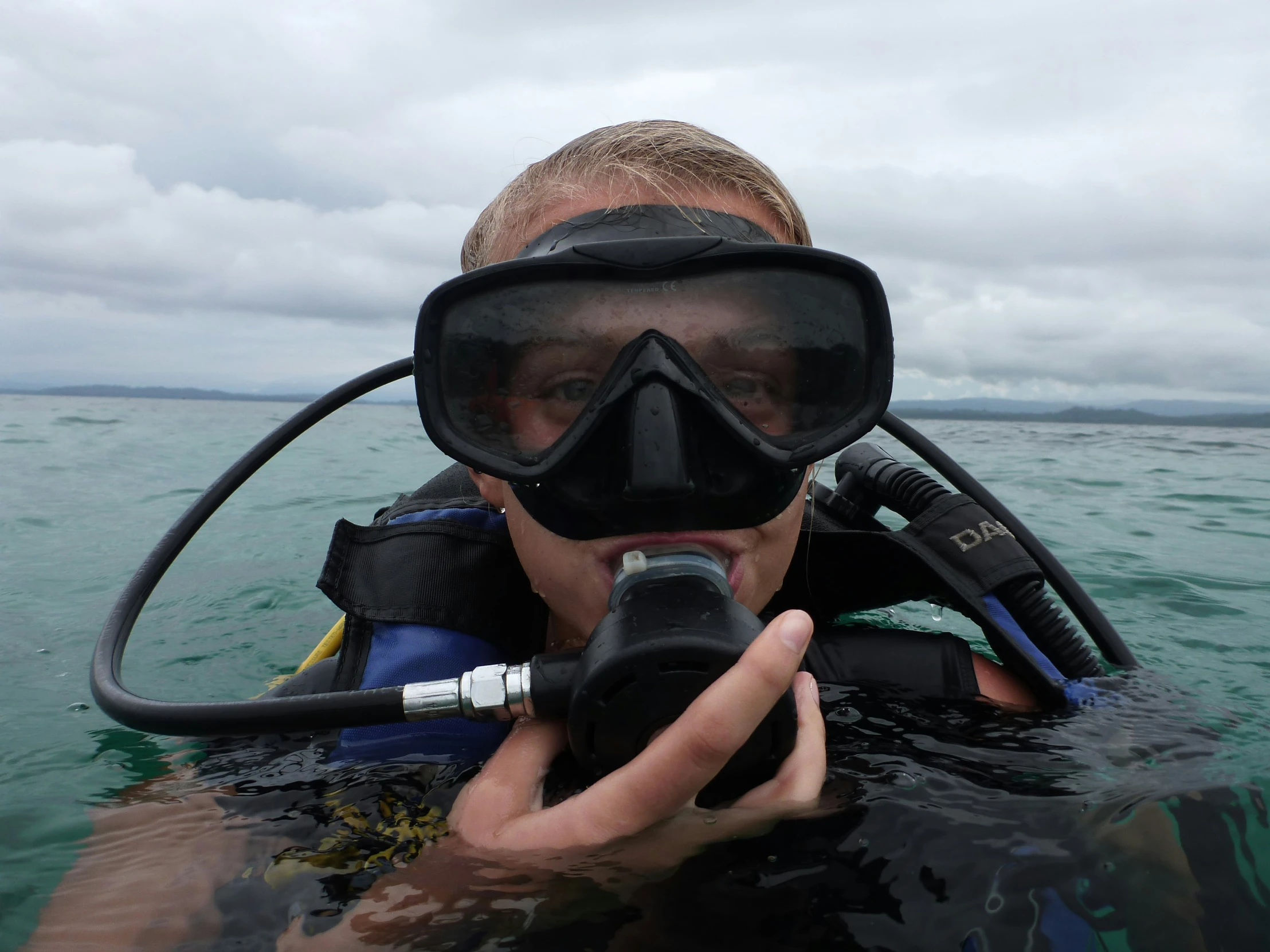 a man wearing a scuba helmet and scuba gear holding up his camera