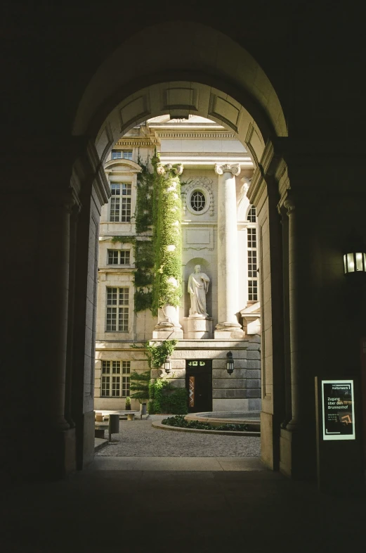 the entrance to a building with a statue in the front yard