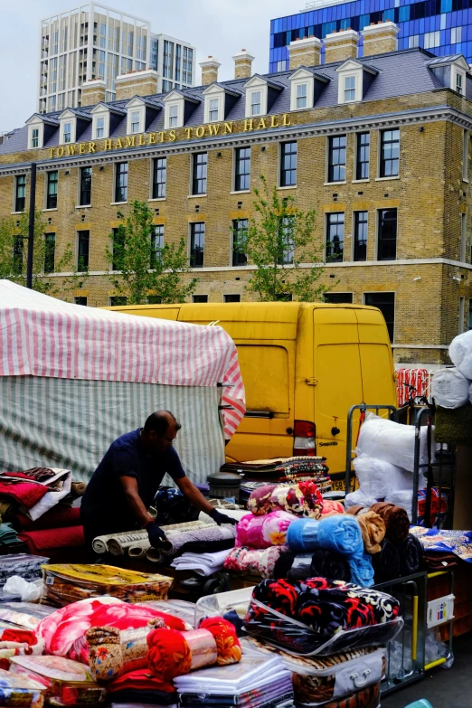 a man in plaid shirt on sidewalk next to covered vendors