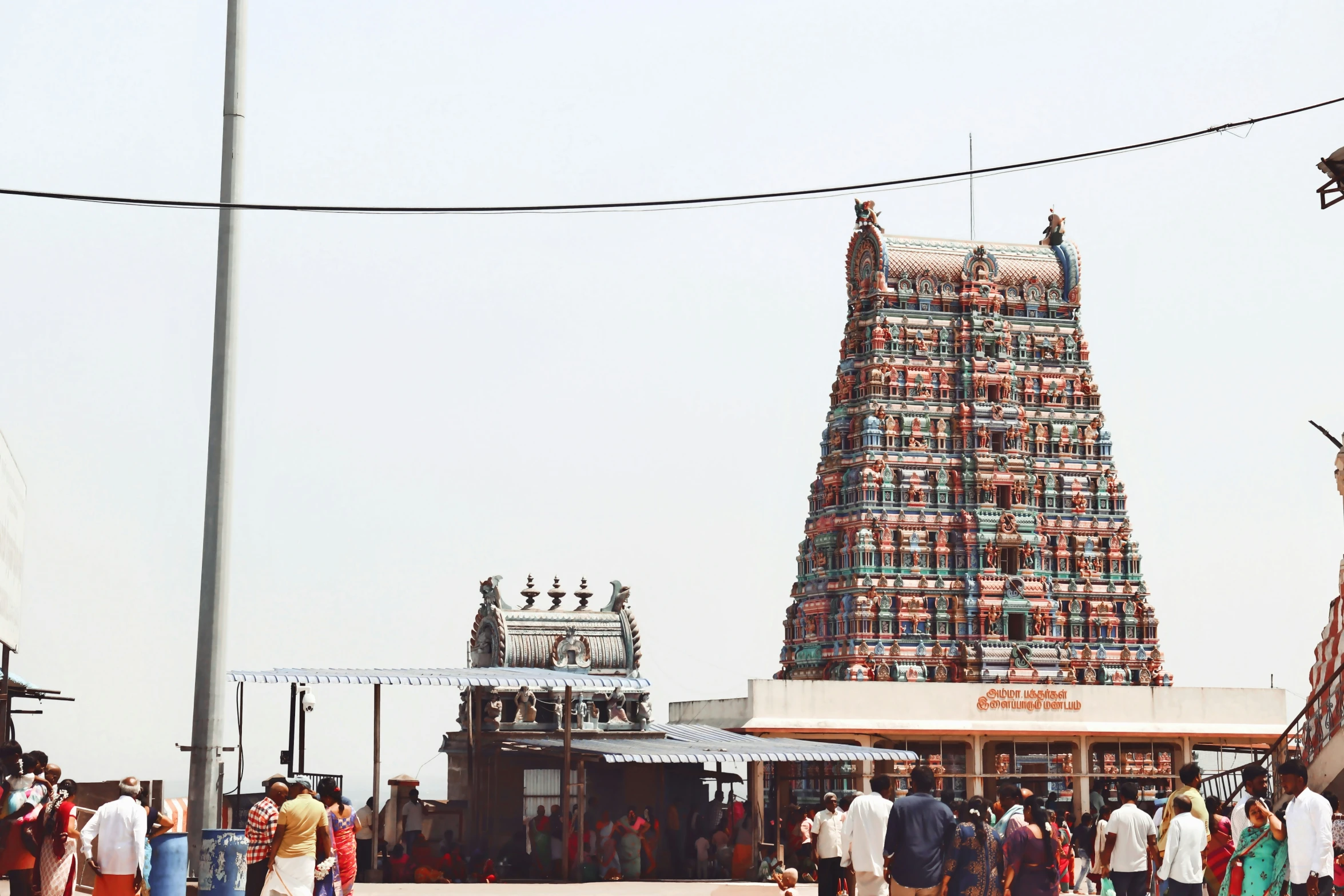 the small temple in the middle of the street has many people around