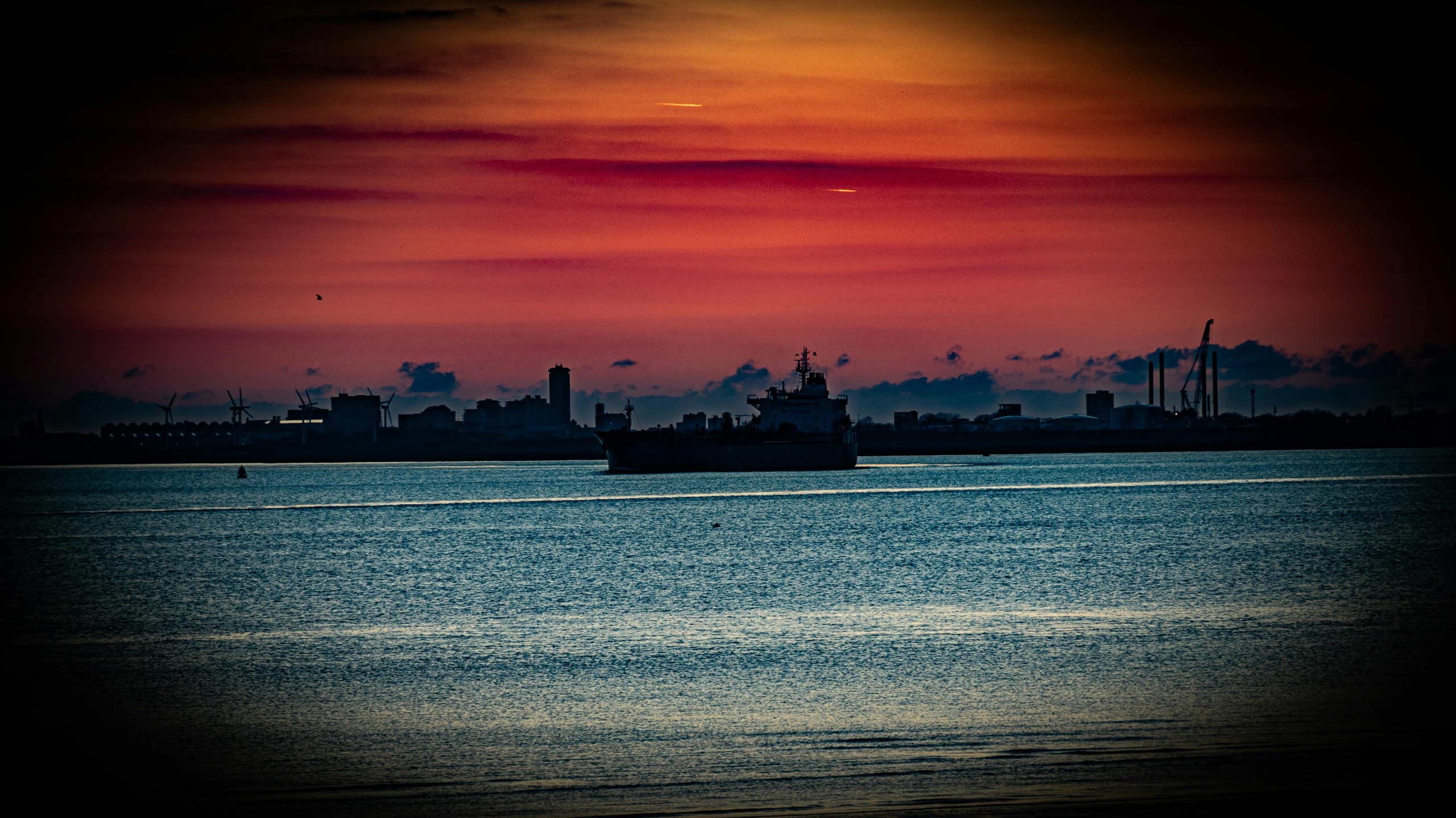 a view of a ship in the ocean near a city