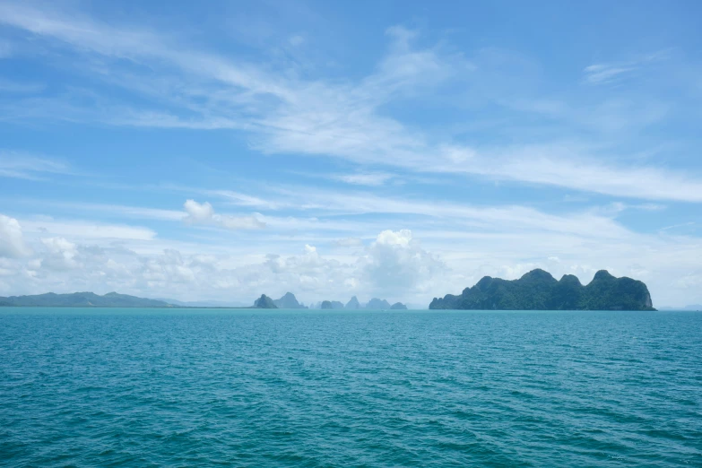 two island are in the ocean on a sunny day