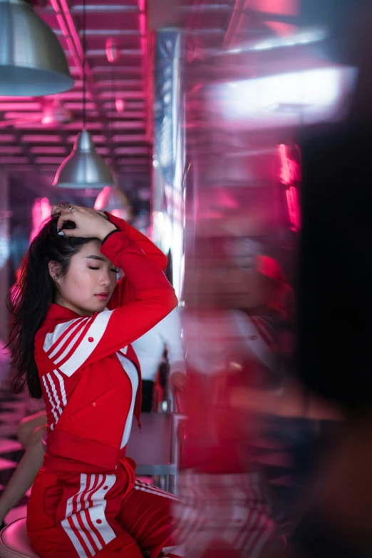 young woman in red and white outfit in front of red lights