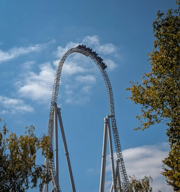 a roller coaster going up against the blue sky